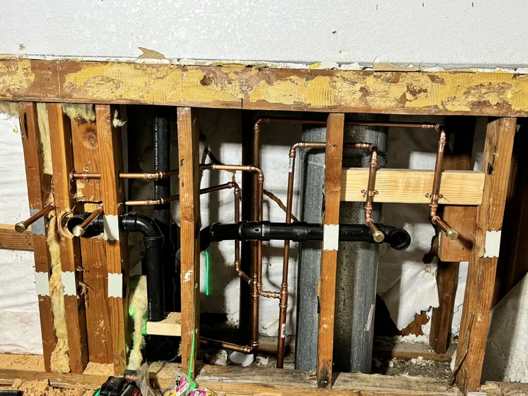 Drains, vents and supply lines in an open wall. A rough inspection looks at this stage, before the wall is closed and tiled.