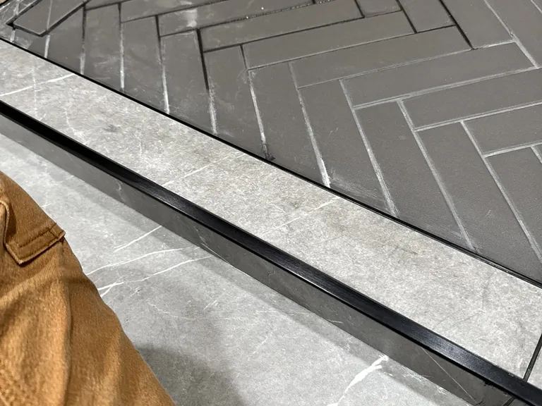 A low curb with a metal edge: easy to step over, and still a clear edge for the water.