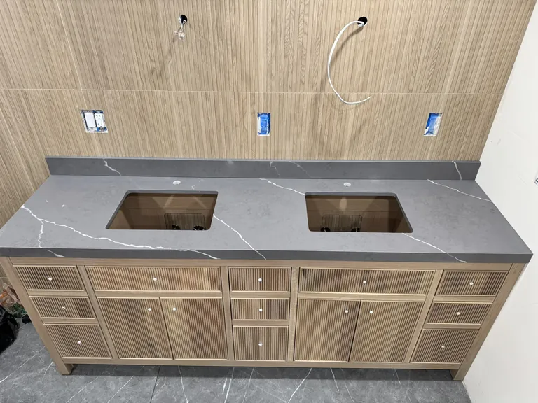 A double vanity in place with its countertop, before the faucets and mirrors go on.