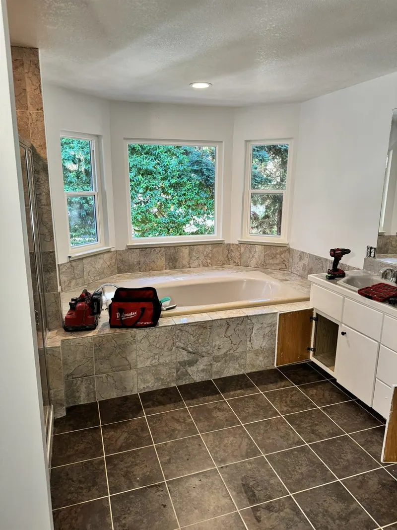 Before: Remodeled bathroom with freestanding tub, oak double vanity and grey porcelain floor